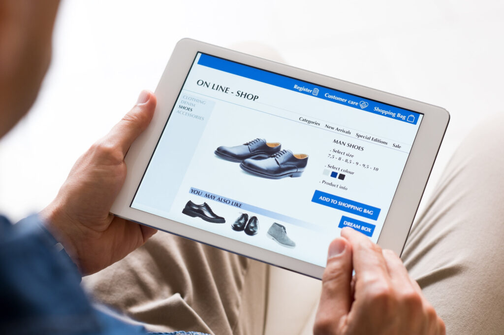 Man shopping online, looking at a product page for dress shoes