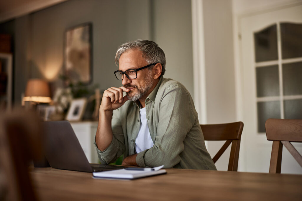 Man pondering while looking at laptop